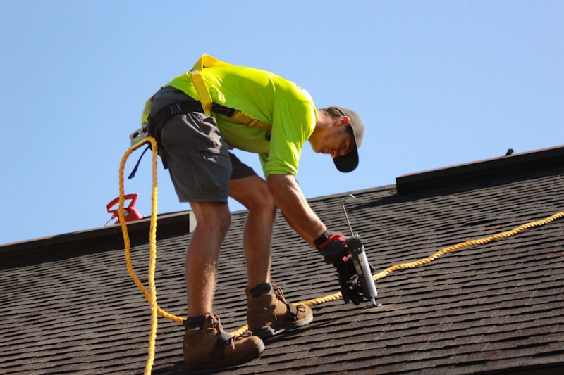 Professional roofer working on residential shingle roof