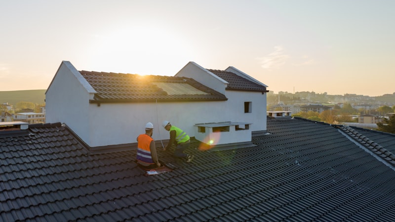 Roofing crew working together at sunset